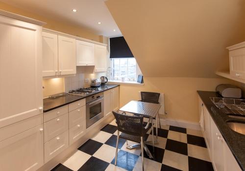 爱丁堡Parliament Sq (apt 5) Royal mile的厨房配有白色橱柜和 ⁇ 格地板