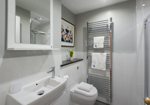 爱丁堡Parliament Sq (apt 10 ) Royal Mile的白色的浴室设有水槽和卫生间。