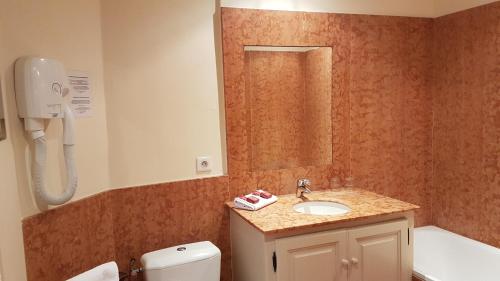 普罗旺斯艾克斯Hotel Cardinal的一间带水槽、卫生间和镜子的浴室