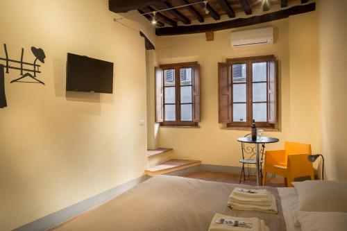 蒙特普齐亚诺Guesthouse Via Di Gracciano - Adults Only的卧室配有一张床,墙上配有电视。