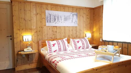 科尔蒂纳丹佩佐盖亚别墅酒店的一间卧室配有一张带木镶板的大床
