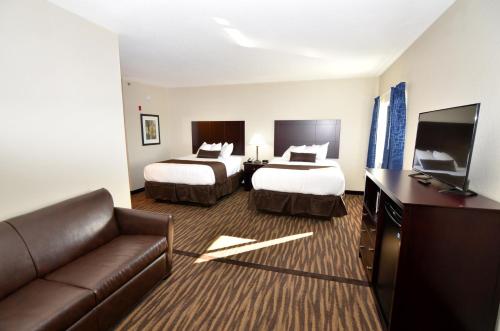 厄尔温Cornerstone Inn & Suites Oelwein的酒店客房,设有两张床和一张沙发