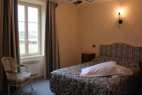 Vereaux德拉美美堡度假屋的一间卧室设有一张床、一个窗口和一把椅子