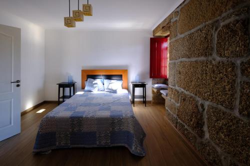 拜昂Casas do Casinhoto - Casa Vista Aregos的一间卧室设有一张床和砖墙