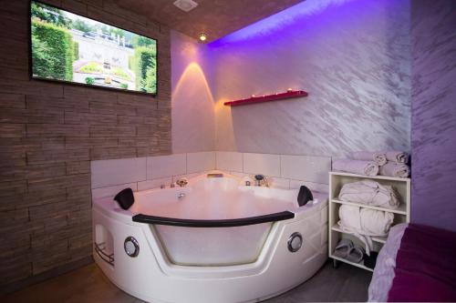 兹拉蒂博尔蓝屋公寓的浴室设有白色大浴缸,拥有紫色照明