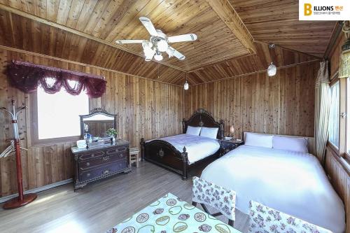 江陵市亿万汽车旅馆的一间卧室配有两张床和吊扇