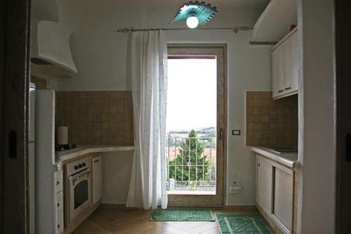 阿列恩图Casa Fioredda的厨房设有大窗户和门