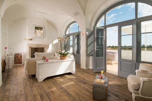 滨海波利尼亚诺Masseria Le Torri的一间白色卧室,配有一张床和一个壁炉