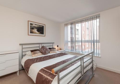 格拉斯哥大都会公寓的一间卧室设有一张床和一个大窗户