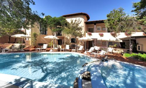 罗通多港科隆纳圣马可酒店的一个带椅子和遮阳伞的大型游泳池