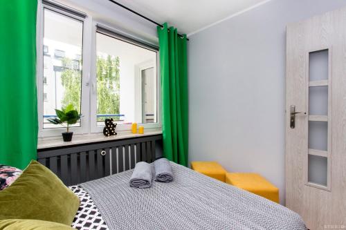 华沙ClickTheFlat Hoża Street Apart Rooms的一间卧室配有绿色窗帘、一张床和窗户