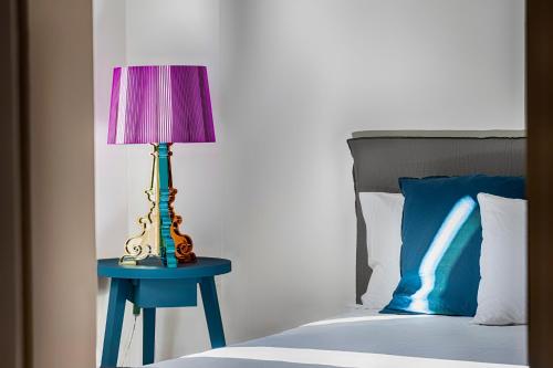 奥里亚Casa Vacanze Torre Palomba的一张蓝色桌子上的紫色灯,床边