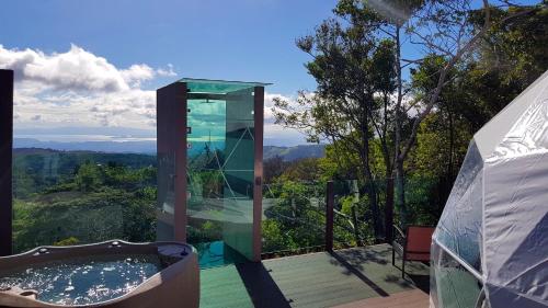 蒙泰韦尔德哥斯达黎加奇拉格兰品蒙特维多酒店的一座玻璃建筑,甲板上设有热水浴缸