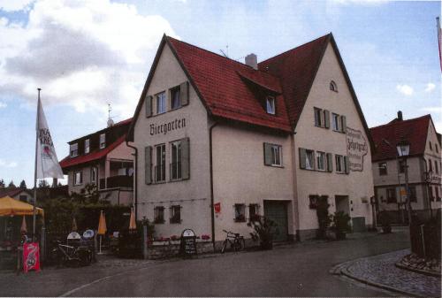 WipfeldGästehaus Zehntgraf的一座白色的大建筑,有红色的屋顶