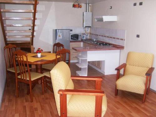 蒙特港Apart Hotel en Puerto Montt的带桌椅的厨房和带吧台的厨房