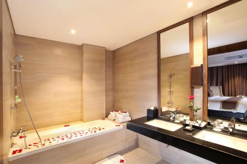 加拉旺卡拉旺瑞士贝尔国际酒店的带浴缸、两个盥洗盆和床的浴室