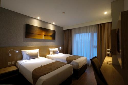 芝卡朗艾耀拉里普斯卡昂酒店的酒店客房设有两张床和电视。