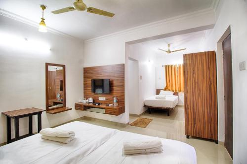 巴加巴加海滩埃尔罗酒店的一间卧室配有一张床,浴室配有电视。