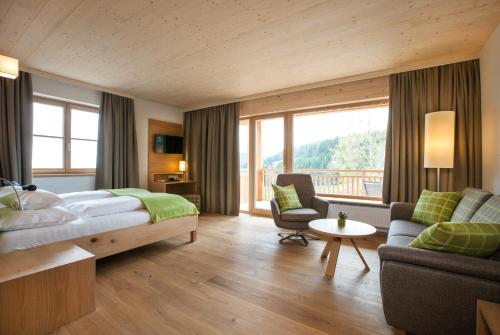 HeilbrunnNaturhotel Bauernhofer的酒店客房设有一张床和一个阳台。