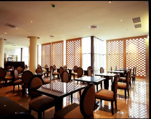 屏东县震点乐汽车商务旅馆的用餐室设有桌椅和窗户。