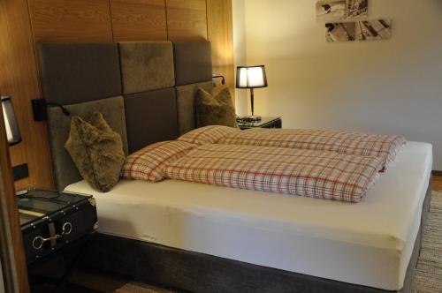 圣安东阿尔贝格Appart Weißschrofenspitze的一间卧室配有一张带 ⁇ 子毯子的床