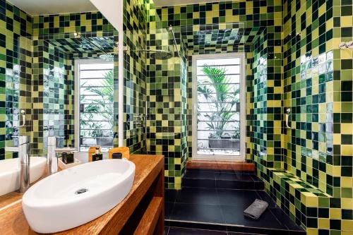 埃斯托利尔Chalet Estoril Luxury Apartments的浴室设有绿色和黄色瓷砖以及水槽