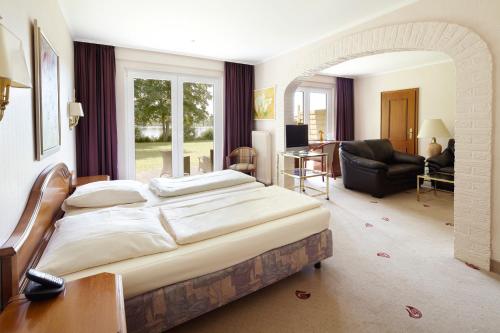 默尔恩Seehotel Schwanenhof的一间带大床的卧室和一间客厅