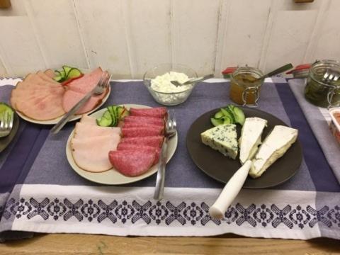 韦斯特罗斯Hotell Hässlö的一张桌子,上面放有两盘肉和奶酪