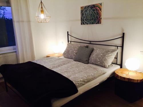 圣温德尔Ferienhaus mit Sonnendeck的一间卧室配有一张带两盏灯的黑色床。