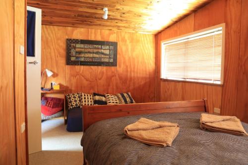 HikutaiaEarthbridge的一间卧室配有一张床,上面有两条毛巾