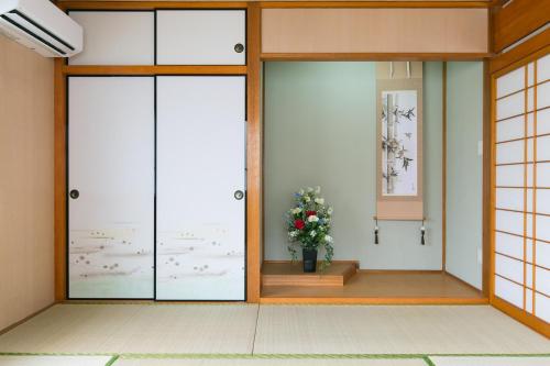 那霸冲绳那霸西方度假屋的一间设有两扇门和花瓶的房间
