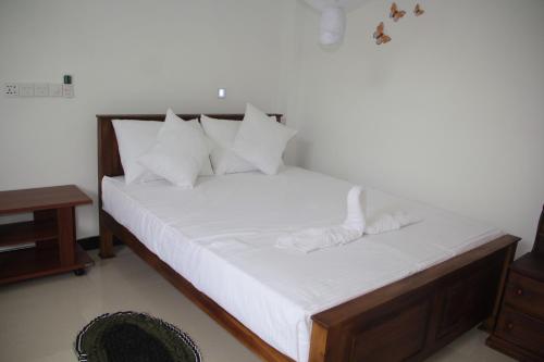 达瓦拉维蝴蝶家园酒店的一张带白色床单和枕头的床