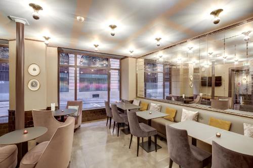巴黎曼特农歌剧院酒店的餐厅设有桌椅和窗户。