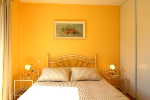 朗通克洛斯布维耶公寓的一间卧室配有一张橙色墙壁的床