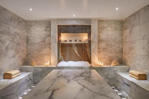 赫尔格达贾兹马卡迪星级Spa度假村的浴室设有大理石浴缸,内配蜡烛