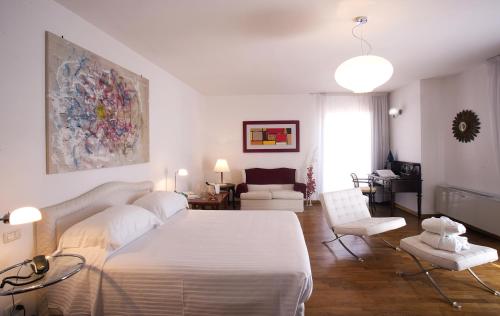 贝尔杰吉Hotel Claudio的一间带白色床的卧室和一间客厅