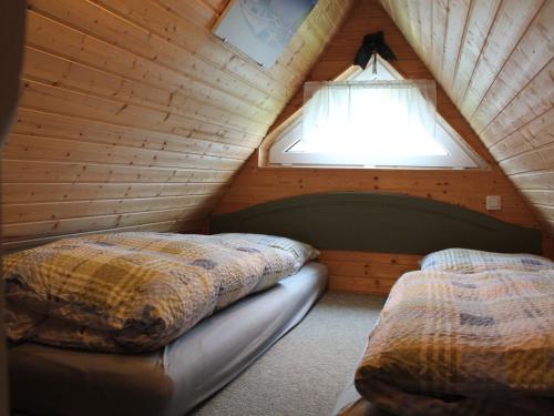 SchwaanQuaint Holiday Home in Schwaan near the Lake的木制阁楼上的卧室配有两张床