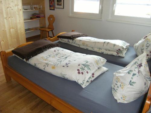 La Côte-aux-Fées尼亚德尔住宿加早餐酒店的客房内的两张床和枕头
