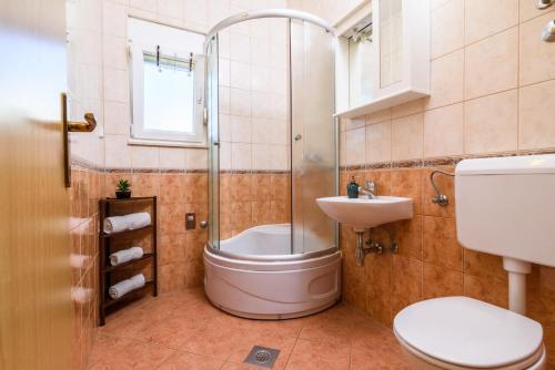 玛里纳Apartments Neve的带淋浴、卫生间和盥洗盆的浴室