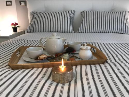 罗马罗马甜蜜之家公寓的床上的带茶具的托盘,带蜡烛