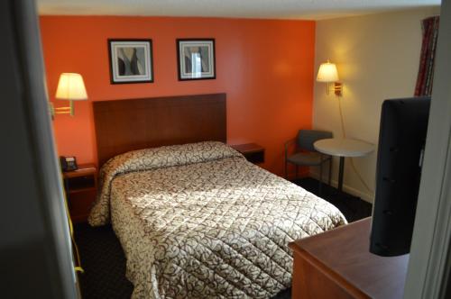 沃特敦皇家汽车旅馆的酒店客房,设有床铺和橙色的墙壁