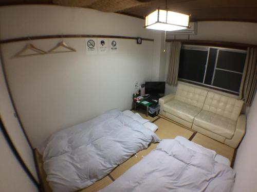 金泽肯若库海苏203号公寓的一间小房间,配有两张床和一张沙发