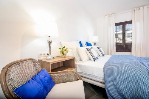 蒂亚斯Rooms & Suites The Lighthouse的卧室配有床、椅子和窗户。