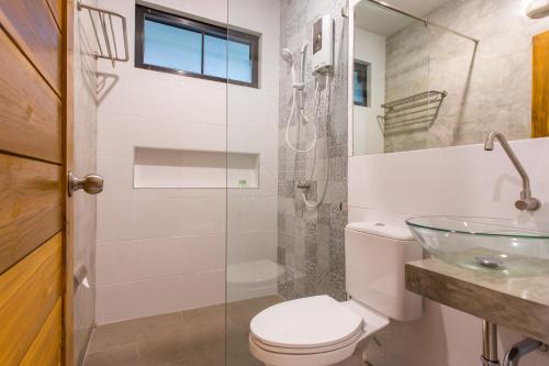 蔻立丽的蔻立度假酒店的一间带卫生间和玻璃淋浴间的浴室