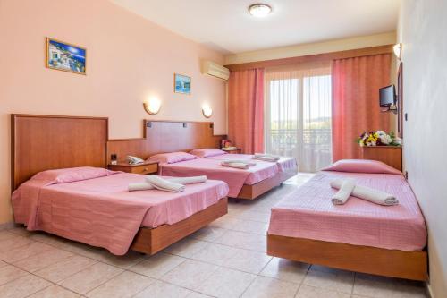 伊利索斯阿丽酒店式公寓的酒店客房,配有3张带粉红色床单的床