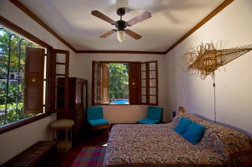 里约热内卢Casa Beleza的一间卧室配有一张床和吊扇