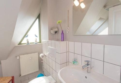 ZirkowFerienhaus am Museumshof的白色的浴室设有水槽和镜子
