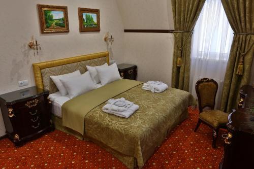 罗夫诺乌克兰罗夫诺酒店 的一间卧室配有一张床,上面有两条毛巾