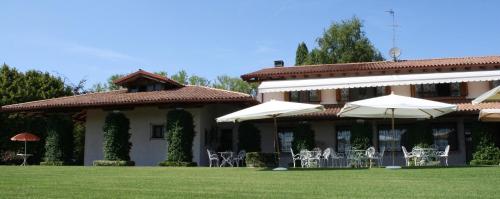 苏塞加纳Country House Accommodation on Dreamway Path - Colfosco di Susegana TV, Veneto, Italy的院子里有椅子和遮阳伞的建筑
