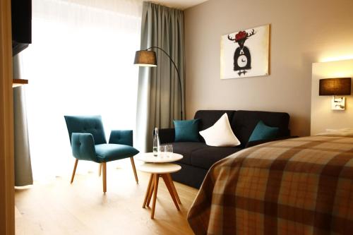 霍伊塞尔恩Gästezimmer Kamino的一间卧室配有一张床、一张沙发和一张桌子